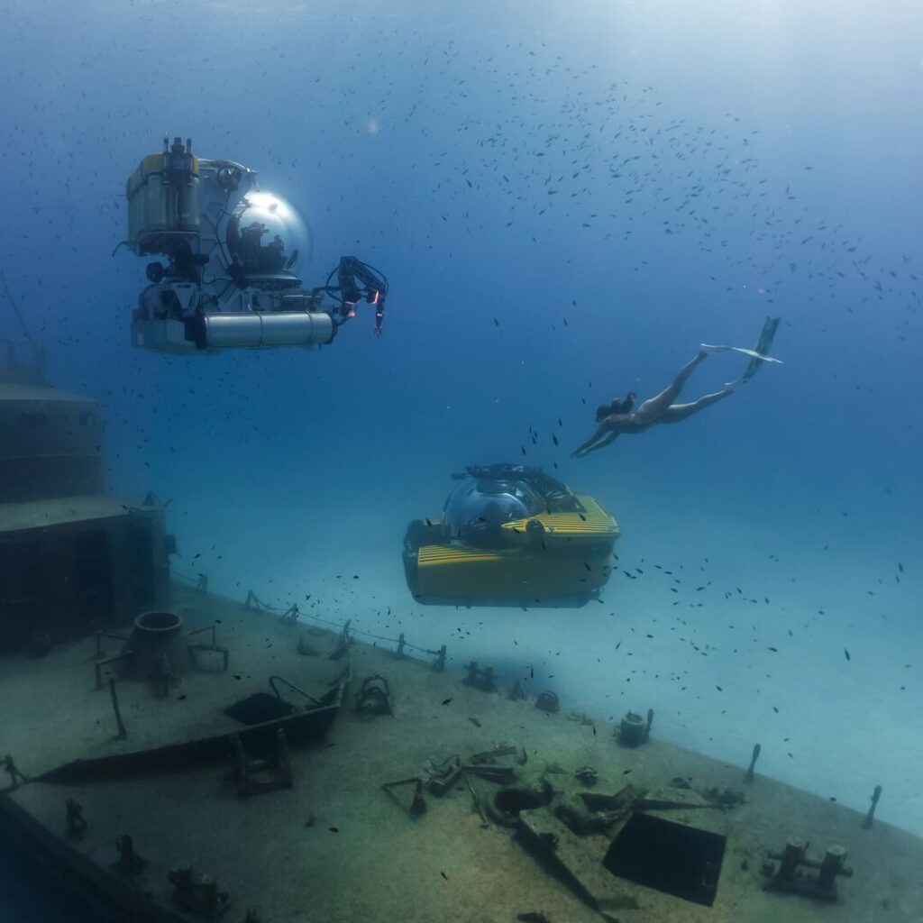 Freediver diving with two subs in the Mediterranean