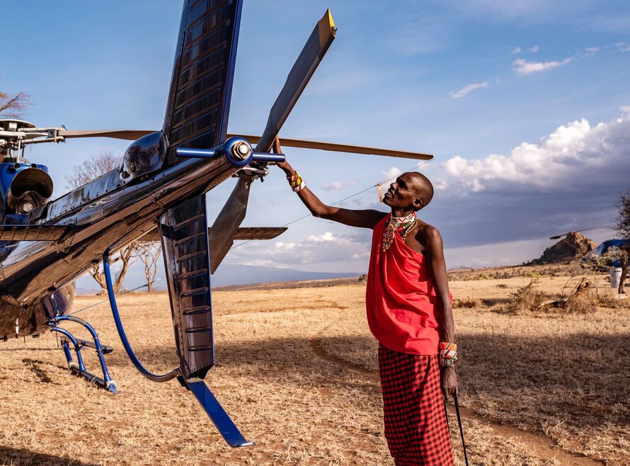 Member of a tribe touching a helicopter.