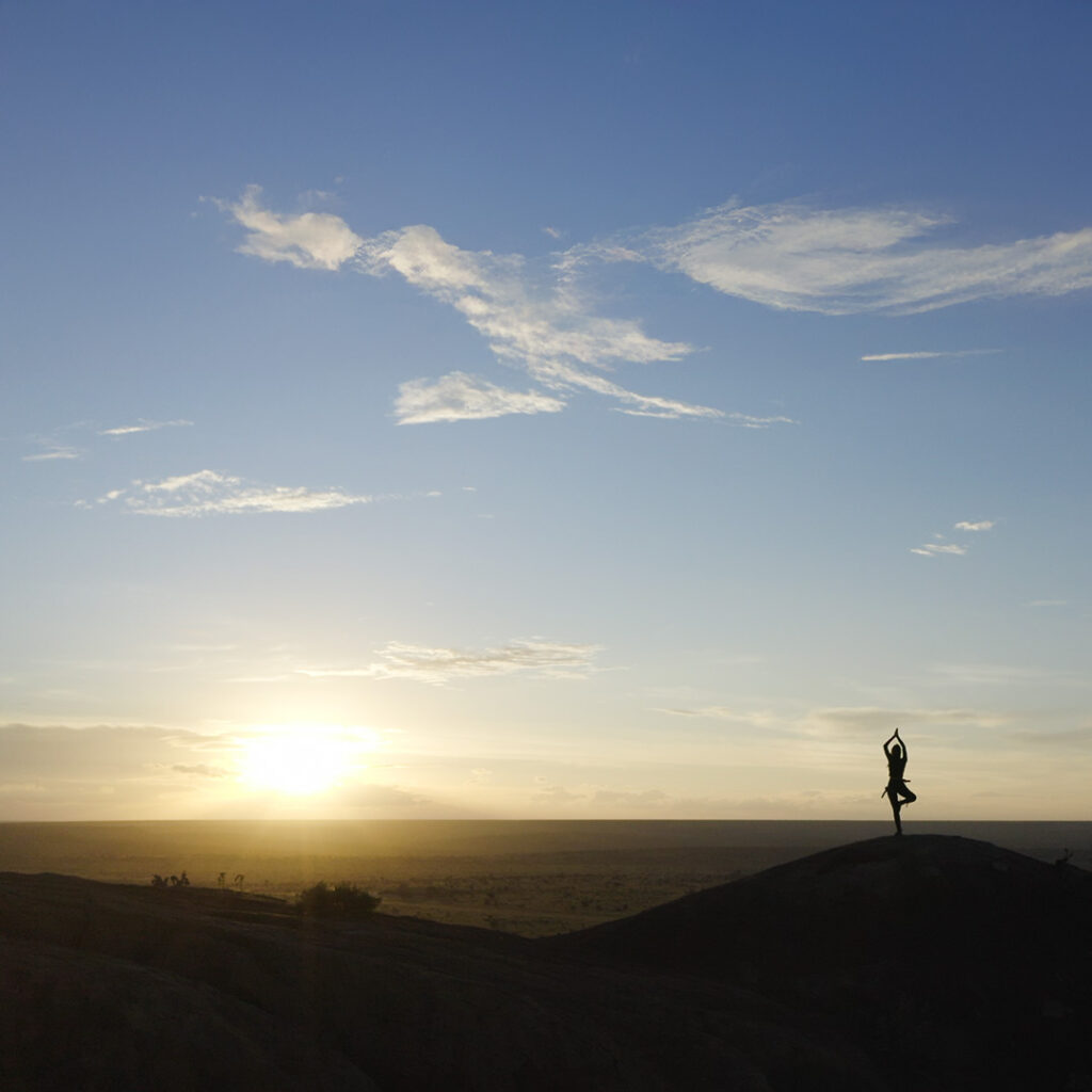 Woman doing yoga at sunset